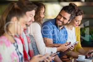 Cheerful friends using mobile phone