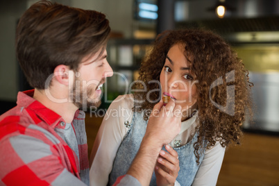 Smiling man feeding cake to woman during celebration