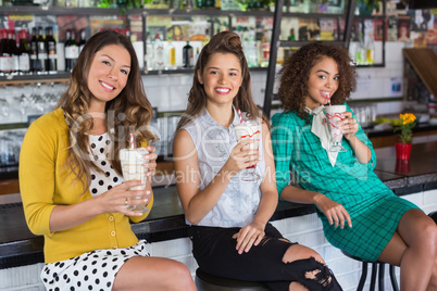 Fashionable female friends having drink in restaurant