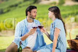 Romantic couple staring at each other while holding wineglasses