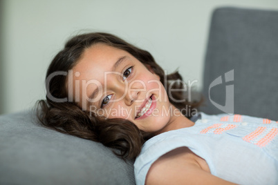 Smiling girl relaxing on sofa in living room