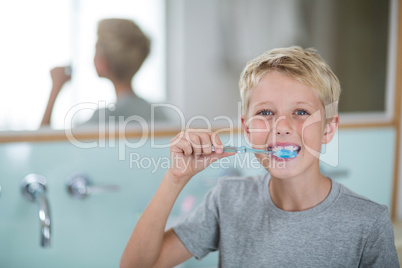 Portrait of boy brushing his teeth in bathroom