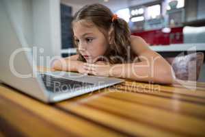 Girl looking at laptop in kitchen