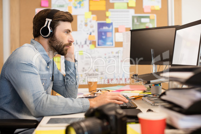 Businessman wearing headphones while working in creative office