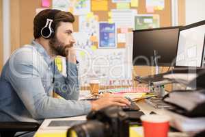 Businessman wearing headphones while working in creative office
