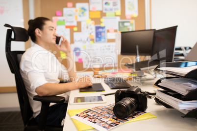 Designer talking on phone in creative office
