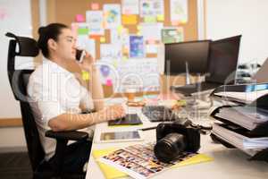 Designer talking on phone in creative office