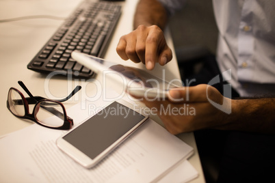 Businessman using digital tablet while sitting in office