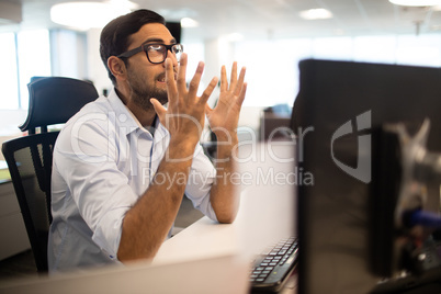 Frustrated businessman clenching teeth in office