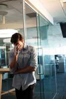 Uphappy businessman standing against glass