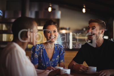 Happy friends interacting while having coffee