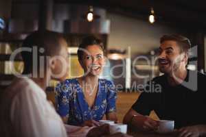 Happy friends interacting while having coffee