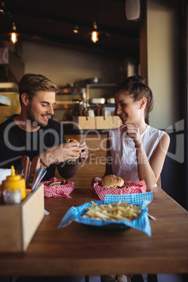 Happy couple interacting while fast food
