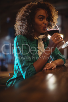 Woman having wine at bar counter