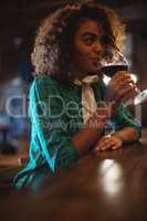 Woman having wine at bar counter