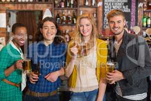Portrait of young friends holding beer bottles