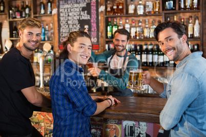 Portrait of smiling friends with bartender