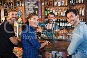 Portrait of smiling friends with bartender