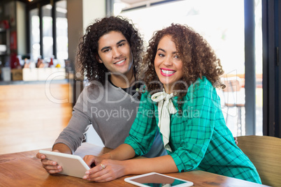 Portrait of young man and woman using digital tablet