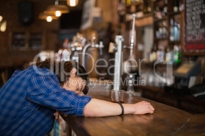 Man leaning on counter in pub