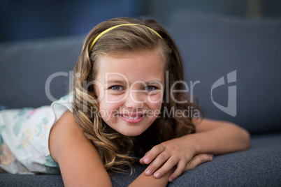 Smiling girl lying on sofa in living room