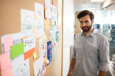 Portrait of businessman standing by soft board