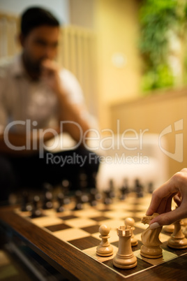 Cropped hand of businesswoman playing chess with male colleague