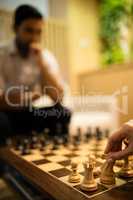 Cropped hand of businesswoman playing chess with male colleague