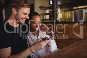 Happy couple using mobile phone