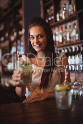 Portrait of female bar tender holding a glass of cocktail