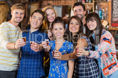 Portrait of happy friends holding short glasses
