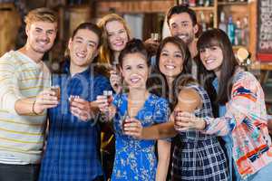 Portrait of happy friends holding short glasses