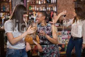 Happy females holding wineglasses