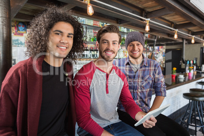 Friends with digital tablet sitting in restaurant