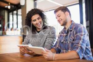 Male friends using digital tablets in restaurant