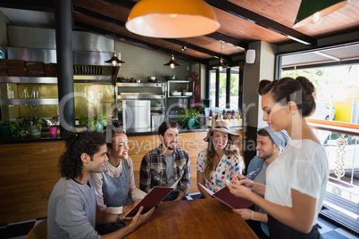 Waitress taking orders from customers in restaurant