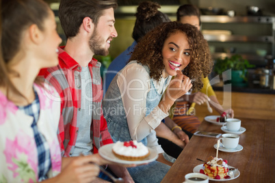 Happy friends having dessert in restaurant