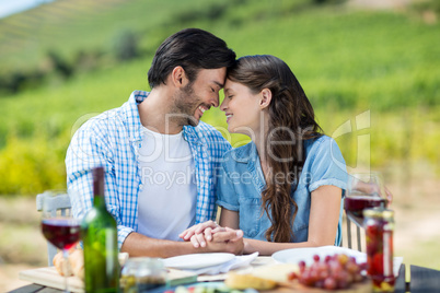 Happy couple holding hands while sitting at table