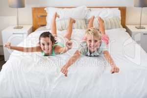 Portrait of smiling siblings having fun on bed