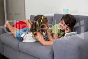 Siblings interacting with each other while using digital tablet