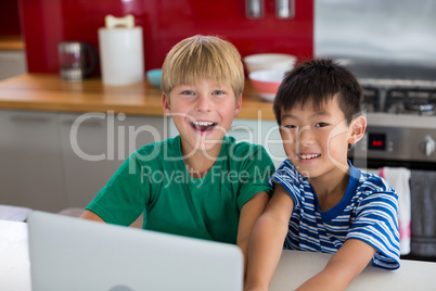 Portrait of smiling siblings standing in kitchen