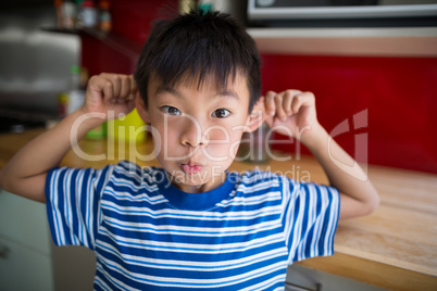 Boy making funny face in kitchen
