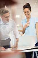 Businessman discussing with happy female colleague at office