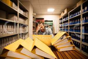 Frustrated businessman using laptop in storage room