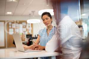 Businesswoman discussing with male colleague in office