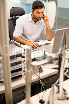 Businessman talking on phone while working in office