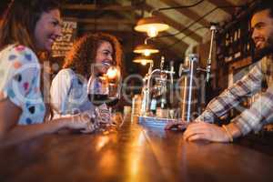 Young women interacting with bartender at counter