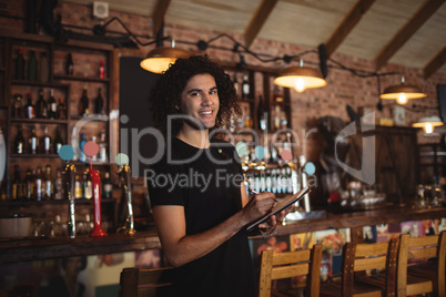 Portrait of young barman writing on diary