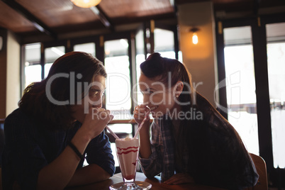 Happy couple having milkshake