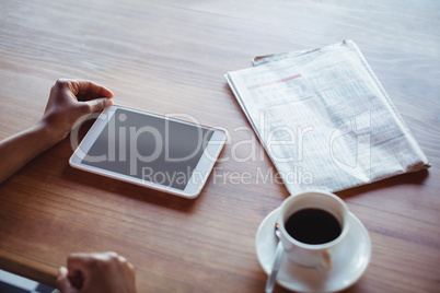 Hands of woman using digital tablet while having coffee